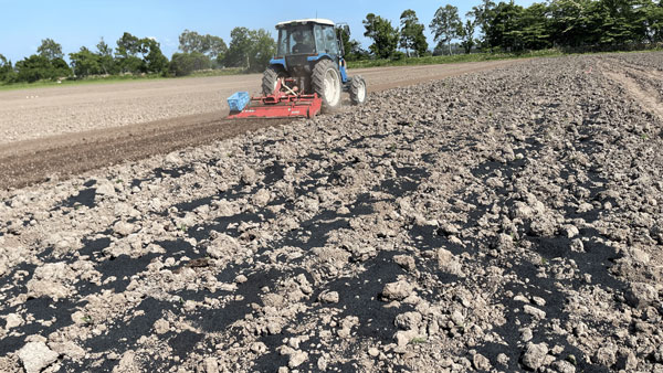 野村ファーム北海道の農地に宙炭を散布して耕す作業