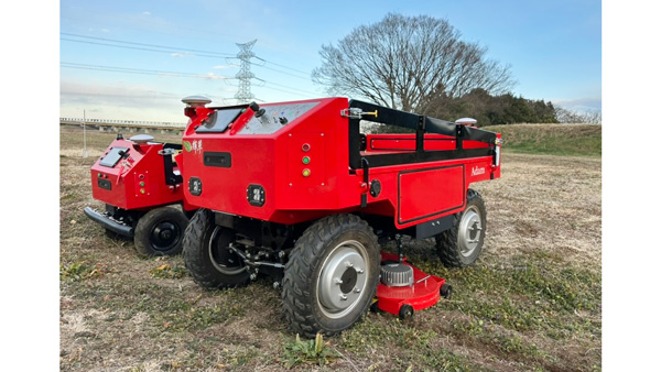 自律走行ロボット「Adam」と、その下部に装着された草刈りアタッチメント（手前）。奥はプロトタイプの「Mini Adam」（2026年発売予定）