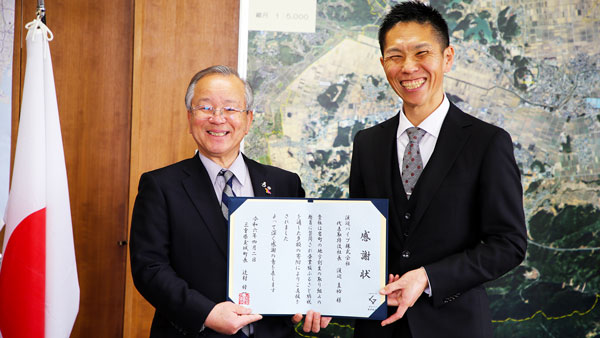 玉城町役場で行われた企業版ふるさと納税の贈呈式。三重県玉城町の辻村修一町長（左）と渡辺パイプ　グリーン事業部の鈴木格方部長（4月2日、三重県度会郡）