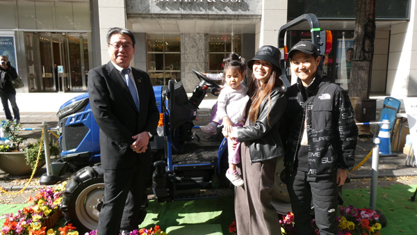 体験イベント参加者との記念撮影に応じた小田切元専務執行役員（左）