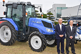 新鋭農機の前で、木下社長（左）と菊池昭夫営業本部長