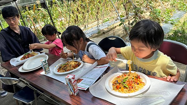自分で栽培・収穫し、料理したスパゲッティを食べる子どもたち