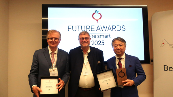 大阪・関西万博 ベルギーパビリオンで開かれた授賞式。「We're Smart World」創設者 フランク・フォル氏（中央）、村上農園の村上 清貴社長（右）、『パーソン・オブ・ザ・イヤー賞』受賞のヘイン・デプレ氏