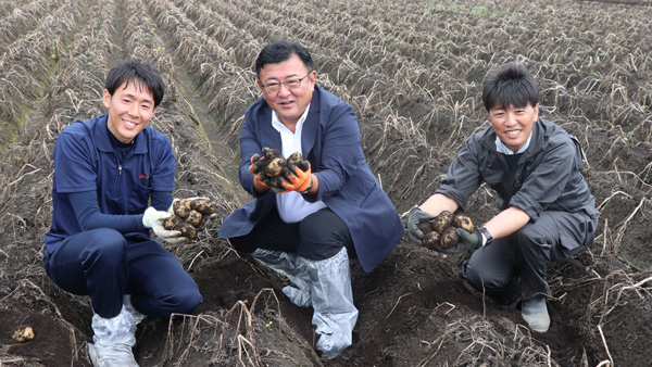 収穫したじゃがいもを手にする岡村支所長（左）、田崎社長（中央）と郷原組合長