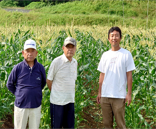 花祭地区で長年とうもろこし栽培を行う土井生紀さん（左）、木下さん（中央）と、栽培指導を受けた花祭果実の唐島晶悟代表